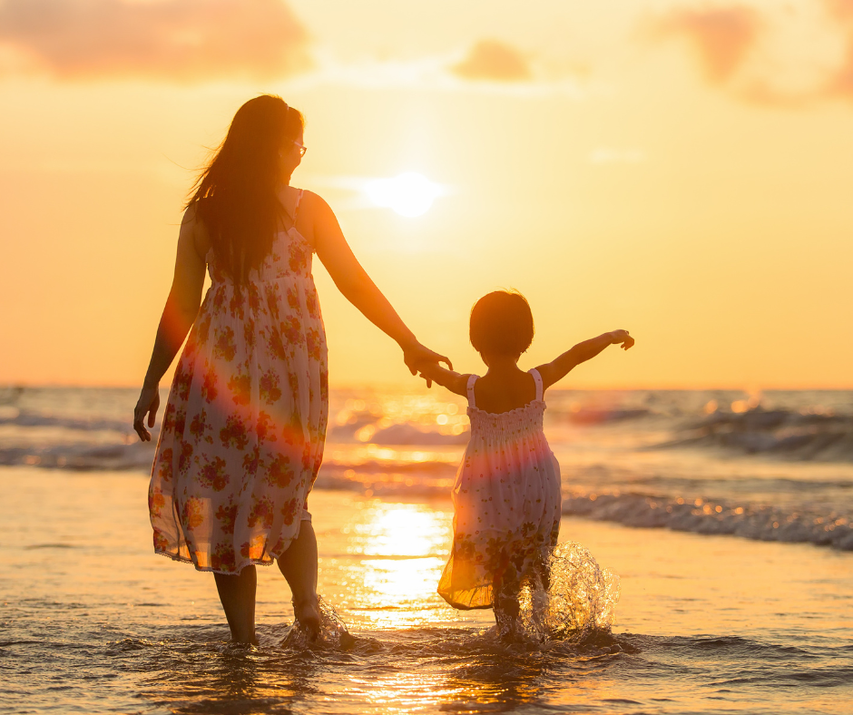 Mother and child at beach sunset